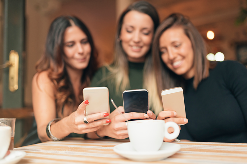 3 women looking at their phones